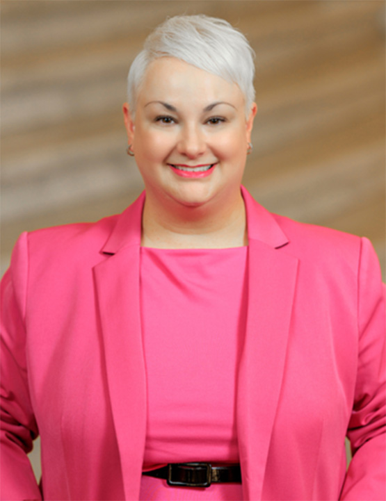 Kathryn Zerfuss is blond and wears a pink suit