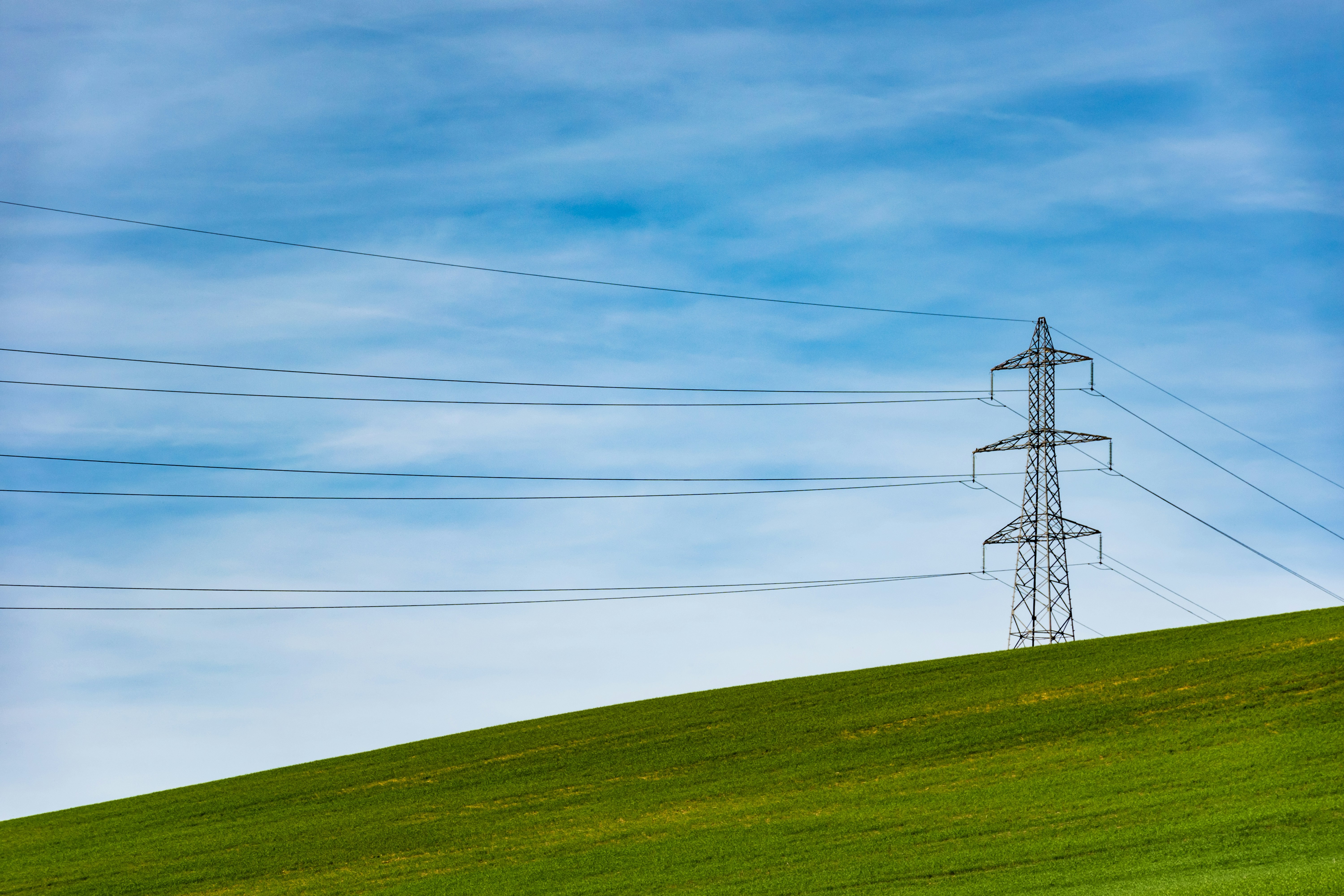 Electricity transmission tower in front of a blue sky