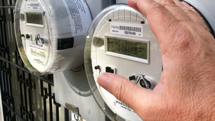 Closeup image of a person reading a household electric meter.
